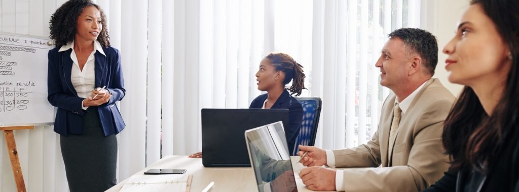 Business people listening to coworker at meeting