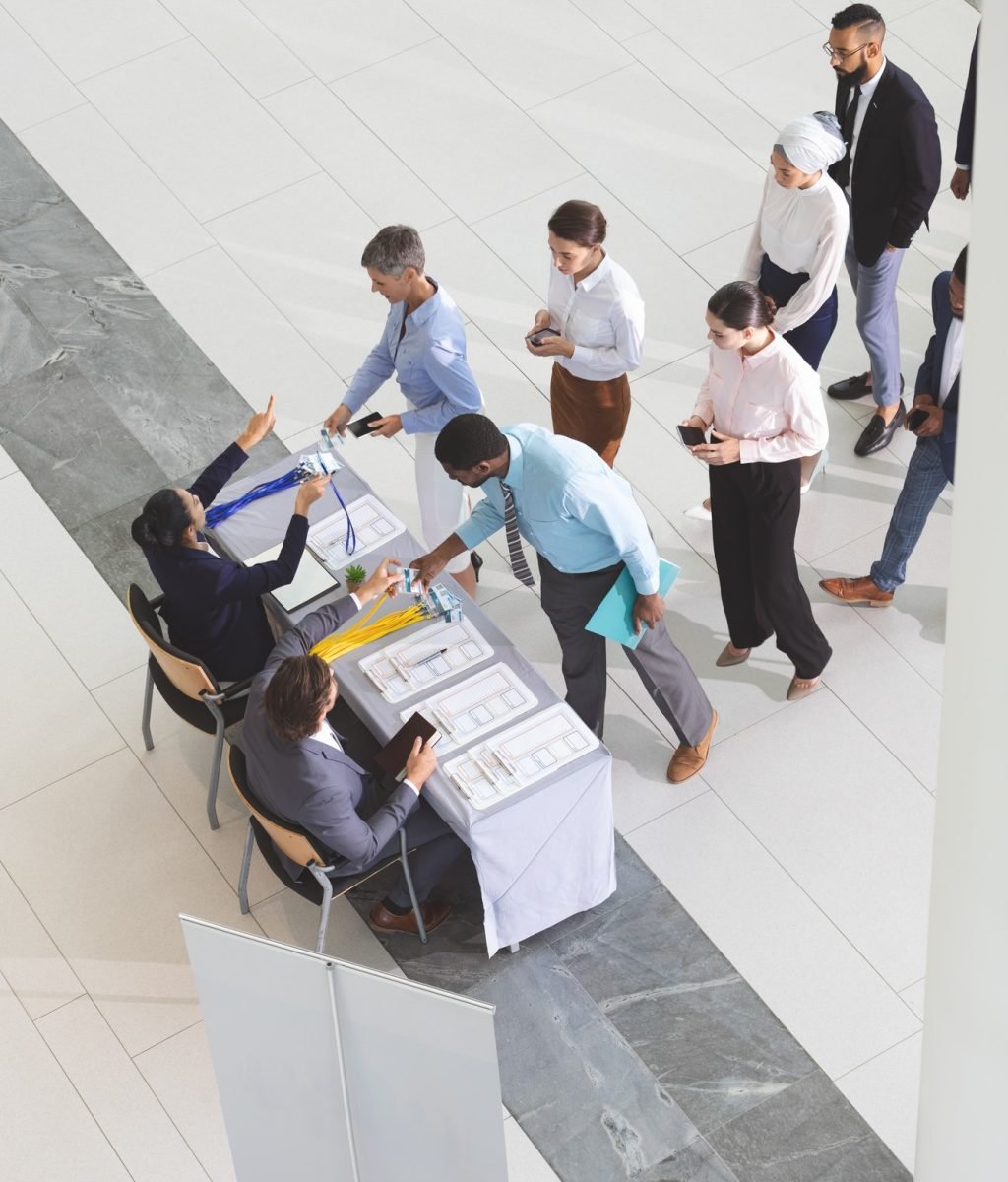 High angle view of diverse business people checking in at conference registration table in lobby