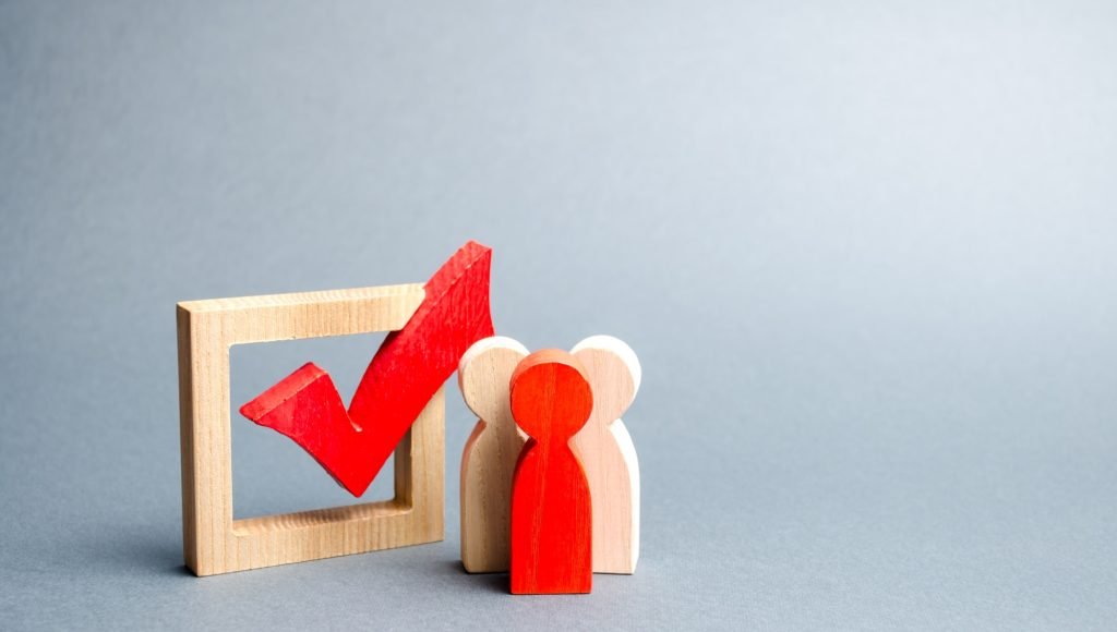 people stand near the checkbox for voting in elections